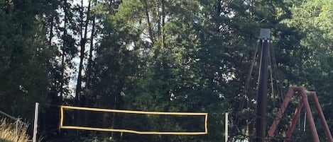 A playground with a swing set and a yellow netted area.