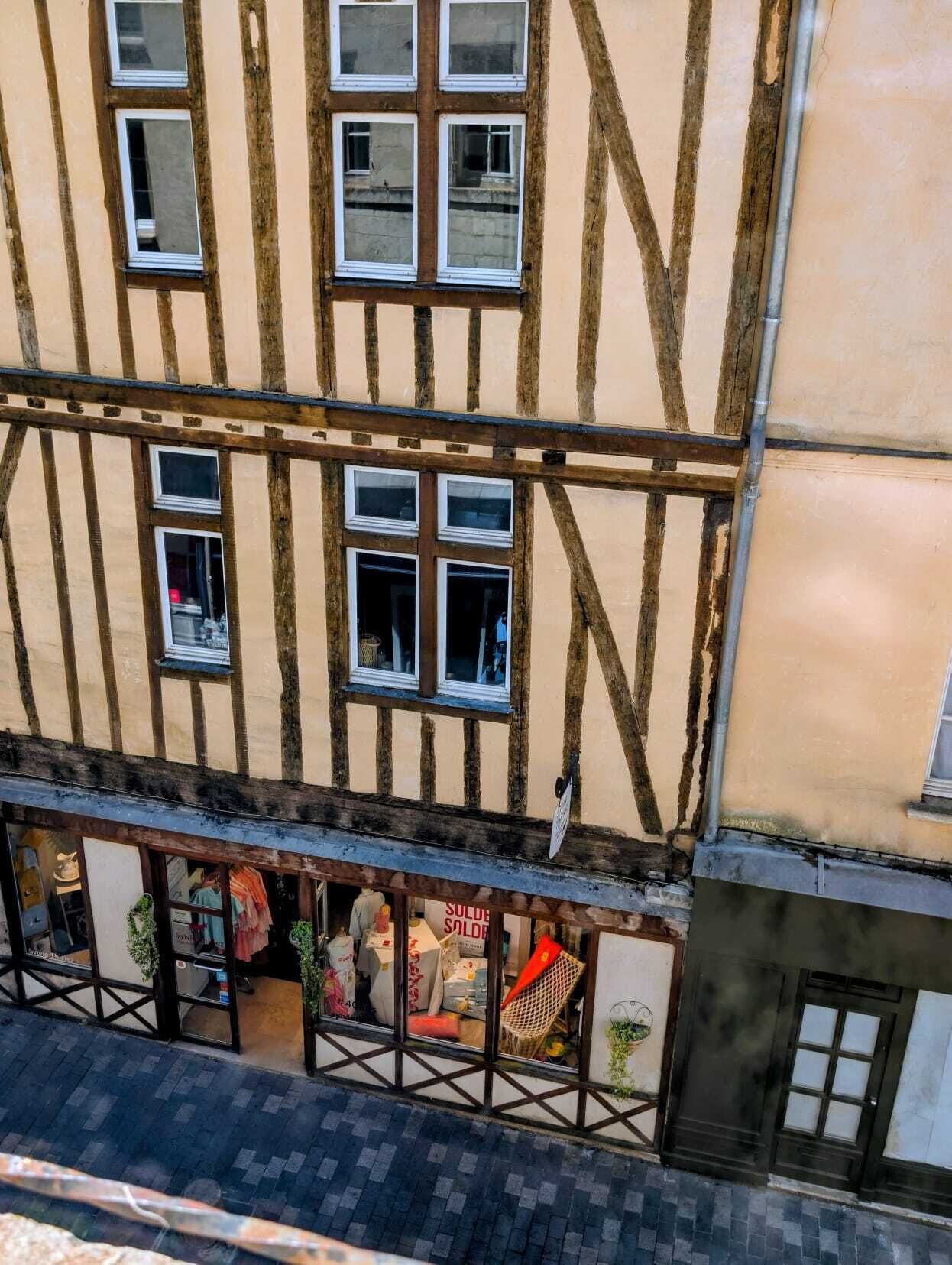 Ein traditionelles Fachwerkhäuschen mit vielen Fenstern und einem Laden im Erdgeschoss.