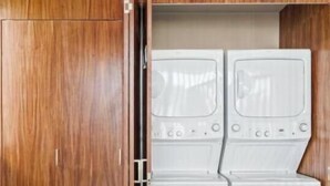 A room with a wooden wardrobe and a built-in washer and dryer unit. - Ocean Boutique Condos (Playa del Carmen)