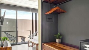A modern bathroom with a wooden vanity, a towel rack, and a potted plant. - Ocean Boutique Condos (Playa del Carmen)