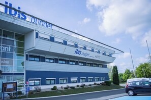 A modern hotel building with a prominent 'ibis budget' sign, multiple windows, and a flat roof. - Ibis Budget Poitiers Site Du Futuroscope (Chasseneuil-du-Poitou)