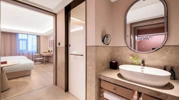 Une salle de bain d’hôtel avec un grand miroir, un lavabo et des toilettes.