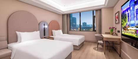 A hotel room with two beds, a desk, a chair, a TV, and a city view.