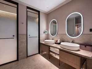 Un baño moderno con dos lavamanos, un espejo grande y un vestidor.