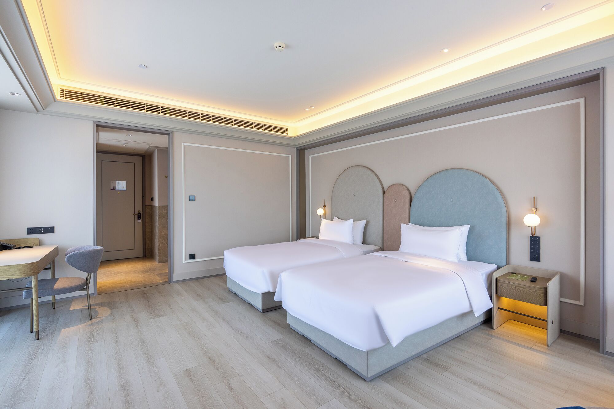 Una habitación de hotel con dos camas, un escritorio y una silla.