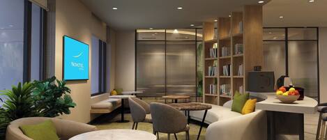 A modern lounge area with seating, a bookshelf, and a television.