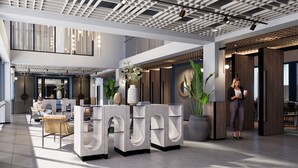 A modern lobby with a reception desk, seating area, and large windows. - Tribe Na Tomba (Nadi)