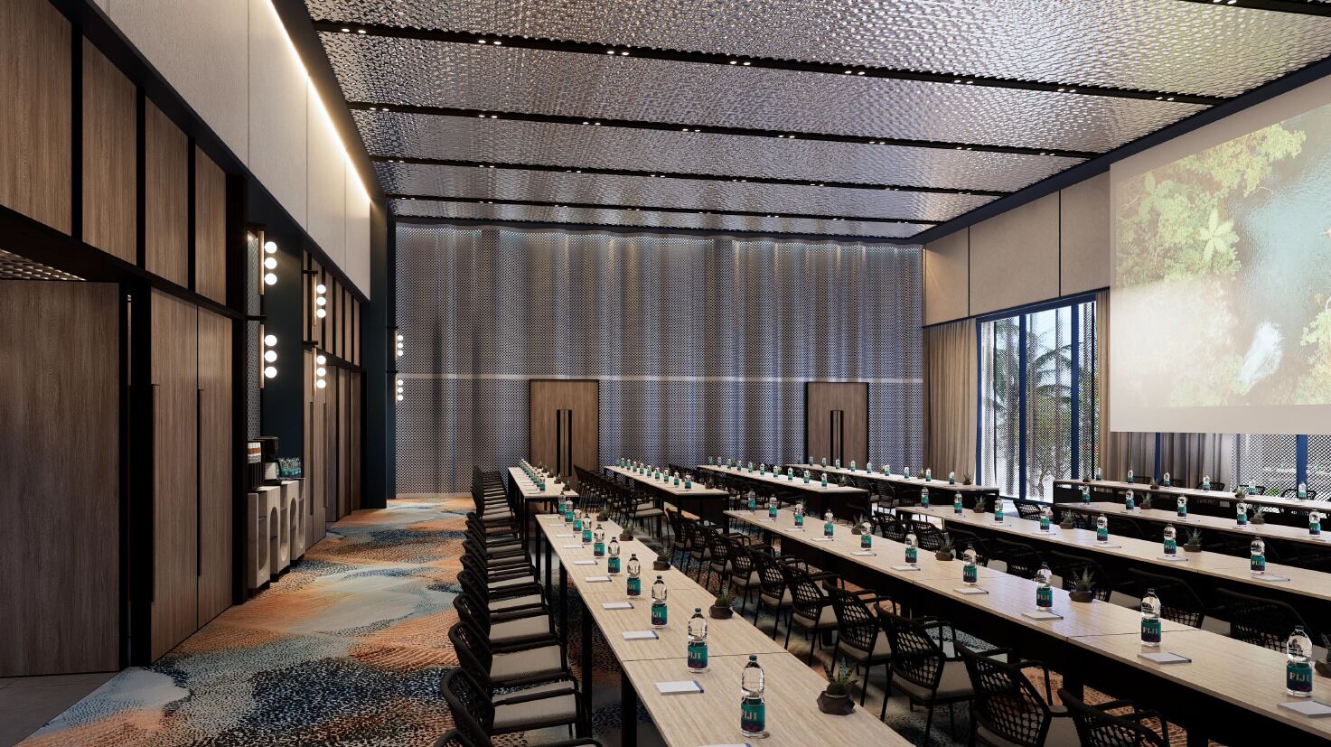 A conference room with long tables, chairs, and a projector screen.