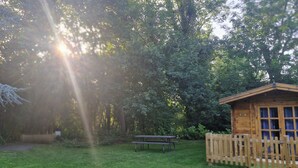 A wooden cabin with a picnic table and a bench in a forested area. - Muntjac Lodge dog Friendly nr Anderby Creek (Alford)