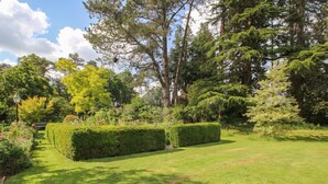 A well-maintained garden with neatly trimmed hedges and a variety of trees. - Chess Cottage (Hereford)