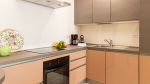 A modern kitchen with a built-in oven, a coffee maker, and a sink. - Designer Home in Center Town (Lucca)
