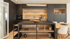 Uma cozinha moderna com bancada de madeira, armários pretos e forno embutido.