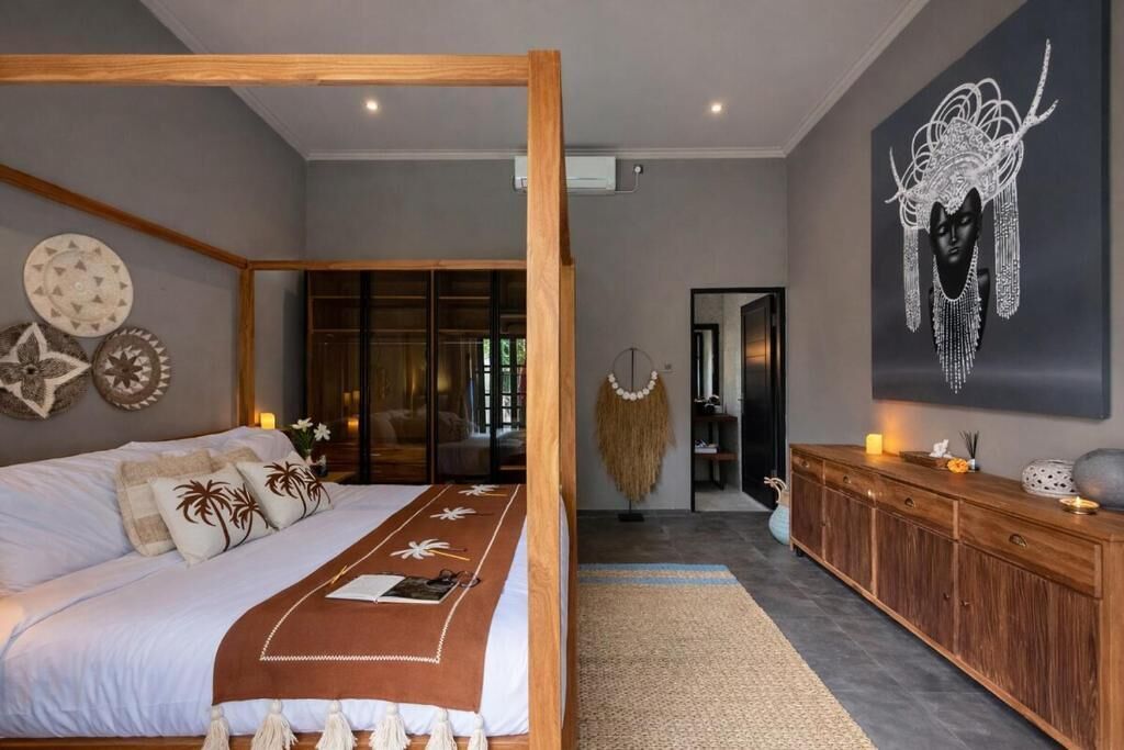 Un dormitorio con una cama grande, cabecera de madera, armario y una obra de arte en la pared.