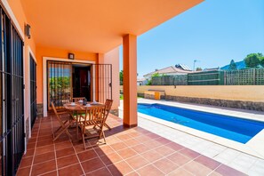 A covered patio with a pool, outdoor furniture, and a view of neighboring houses. - Cubo's Amapola House / Private pool / BBQ / Free Wi-Fi (Alhaurin de la Torre)