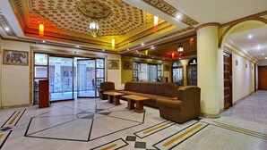 Una hall con soffitto decorato, un'area salotto e una reception.