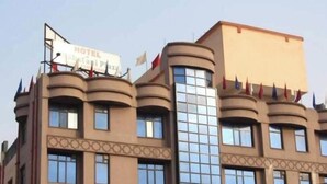 Un edificio di un hotel, con una targa che indica la sua funzione di hotel.