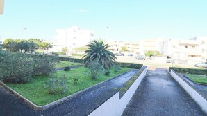 Zona residenziale con un vialetto, aree verdi e edifici sullo sfondo.
