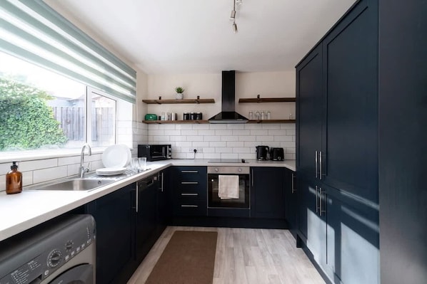 A compact kitchen with a built-in oven, a microwave, and a coffee maker.