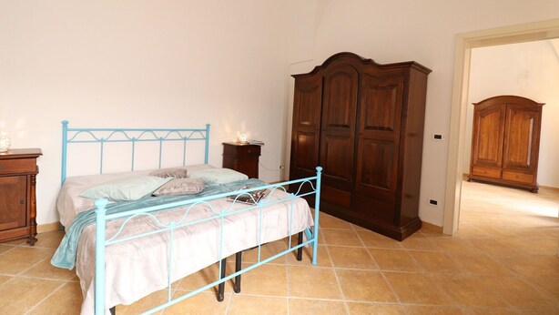 Um quarto com uma cama, um guarda-roupa e uma mesa de cabeceira.
