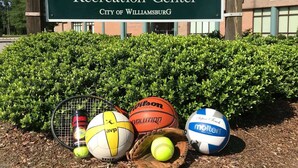 Naamplaatje voor het Quarterpath Recreation Center met sportattributen voor de deur.