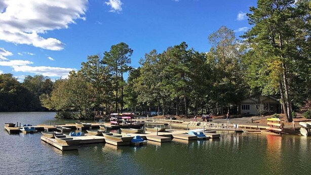 A lakeside dock with boats, surrounded by trees and a clear sky. - Pet-Friendly Room | Free Breakfast (Williamsburg)
