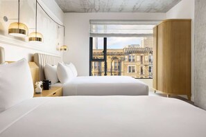 A hotel room with two beds, a view of a cityscape, and a large wooden wardrobe. - Close to Moscone Center + Rooftop Restaurant & Bar (San Francisco)