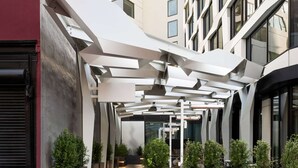 Un bâtiment moderne doté d’une passerelle couverte et de jardinières disposées le long des façades.