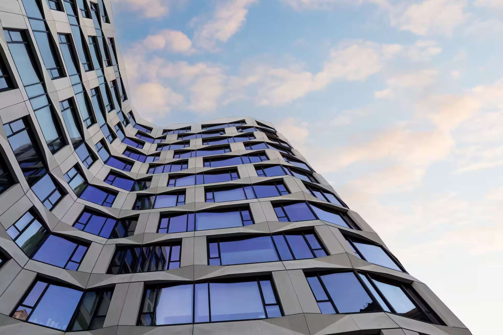 Un bâtiment moderne doté d’une façade incurvée et de nombreuses fenêtres.