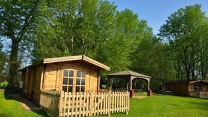 A wooden cabin with a fenced area, a picnic table, and a gazebo in a park. - Bluebell Lodge Dog Friendly, nr Anderby Creek (Alford)