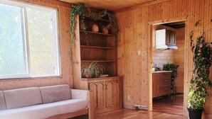 Ein Holzinnenraum mit einer Couch, einem Schrank und einem Deckenventilator.