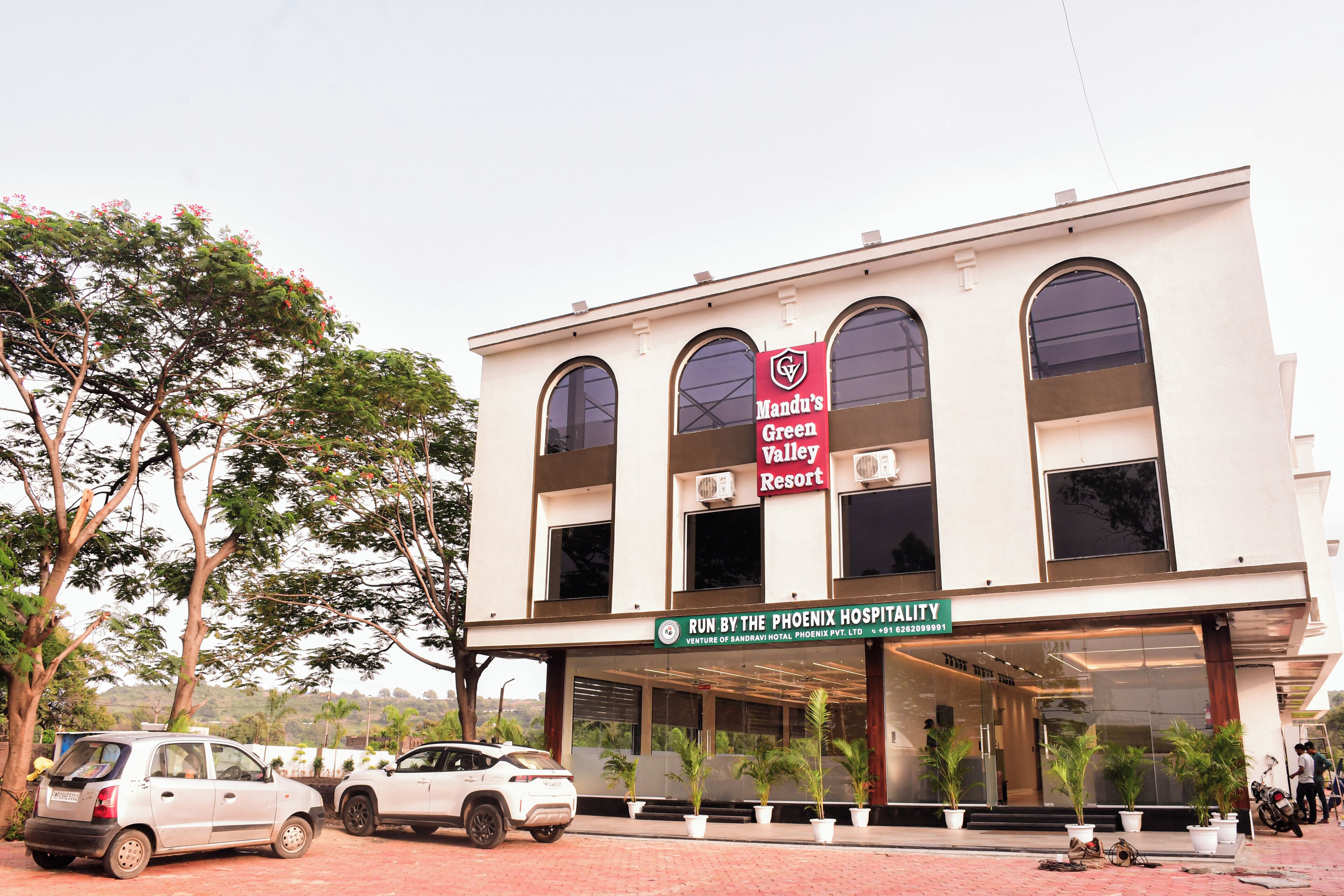 Un edificio con un letrero que dice 'Mandu's Green Valley Resort' y 'Gestionado por Phoenix Hospitality'.