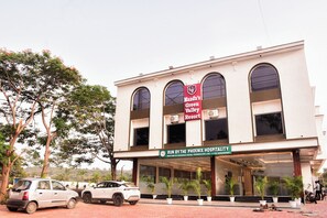 A building with a sign for 'Mandu's Green Valley Resort' and 'Run by the Phoenix Hospitality.' - Mandu's Green Valley Resort (Mandav)