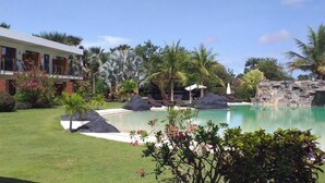 A modern hotel with a pool, surrounded by tropical vegetation and a clear blue sky. - LE KEPARANGA (Mbour)