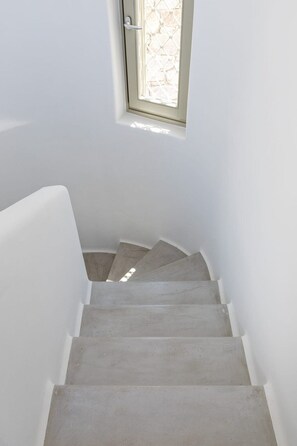 Eine Treppe mit Handlauf und einem Fenster am oberen Ende.