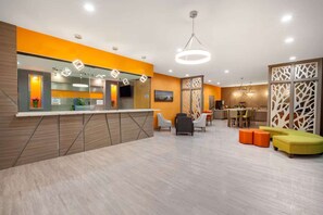 A modern reception area with a counter, seating, and a dining area. - Airport Stay with Free Breakfast & Parking + Gym (Houston)