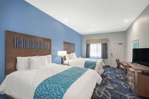 A hotel room with two beds, a desk, a chair, a television, and a window with curtains. - Airport Stay with Free Breakfast & Parking + Gym (Houston)