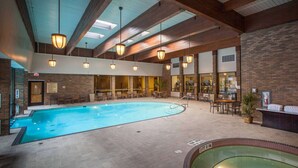 An indoor swimming pool with a tiled floor, surrounded by seating areas and a brick wall. - Easy Access To Downtown + Free Parking&Restaurant (Pittsburgh)