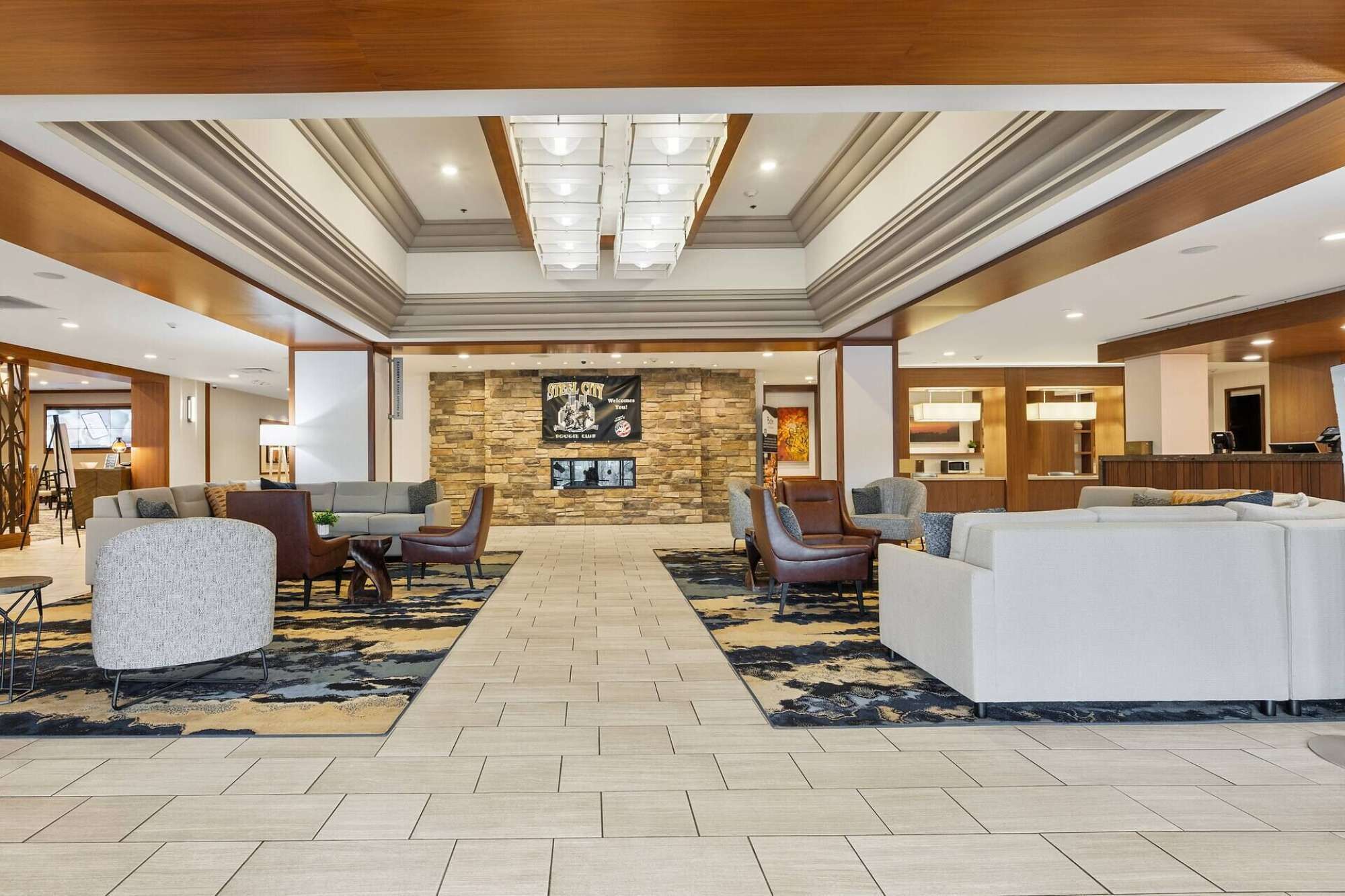A spacious lobby with a central seating area, a stone accent wall, and a reception desk.