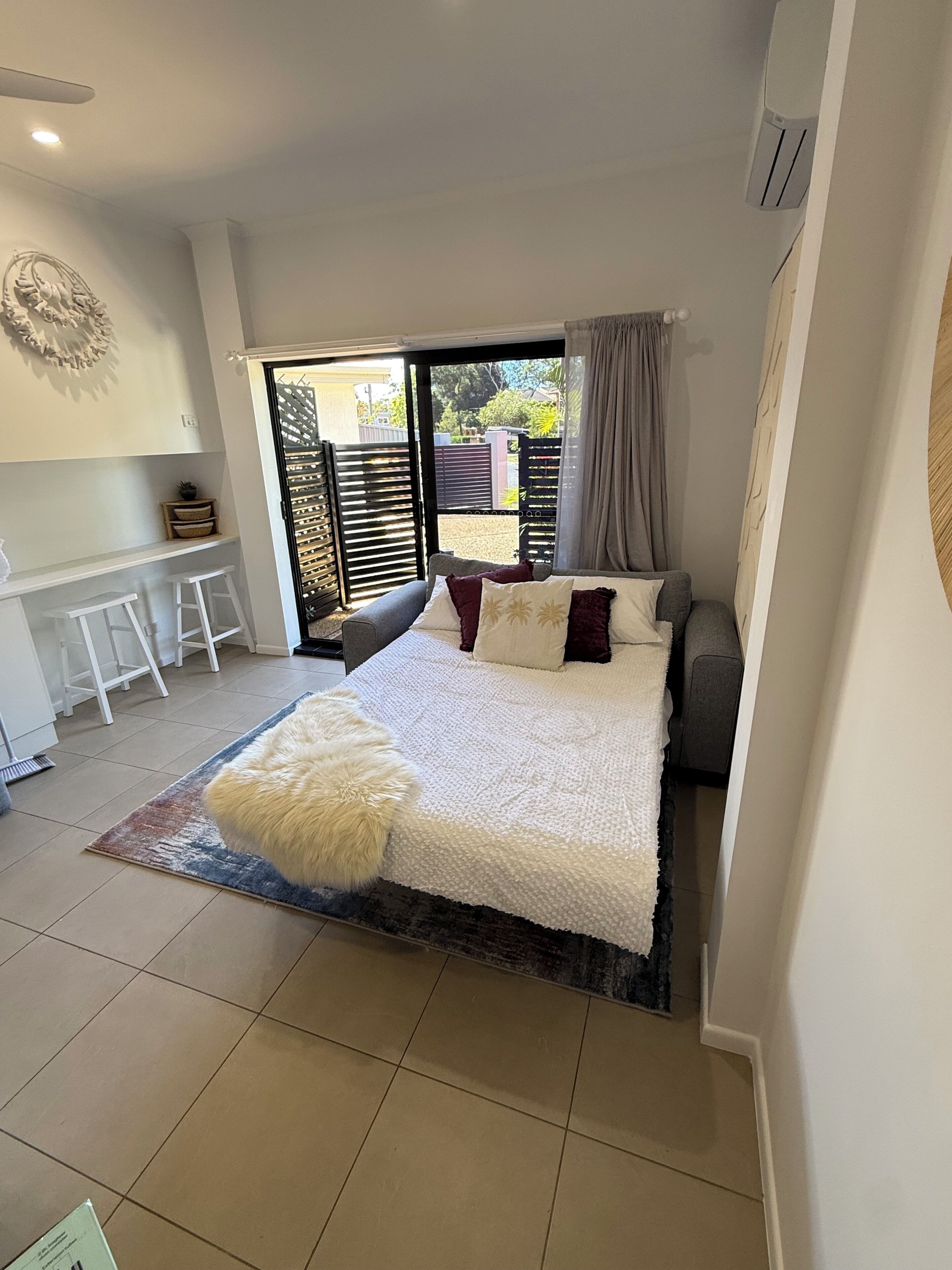 Une chambre à coucher avec un lit, un bureau et une vue sur l’extérieur.