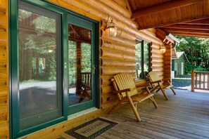 A log cabin with a porch, two Adirondack chairs, and a welcome mat. - Misty Mountain River House*Fire Pit*Private Cabin (Tillamook)