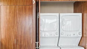 A room with a wooden wardrobe and a built-in washer and dryer unit. - Ocean Boutique Condos (Playa del Carmen)
