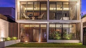 Ein mehrstöckiges Gebäude mit modernem Design, mit Balkonen und großen Fenstern.