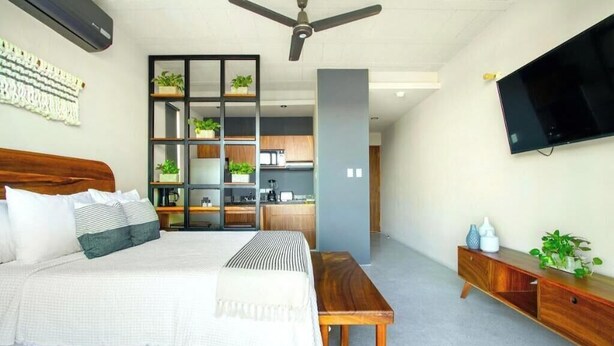 Ein Schlafzimmer mit Bett, Nachttisch und einem an der Wand befestigten Fernseher.