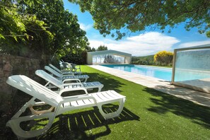 A poolside area with lounge chairs and a glass-enclosed structure. - Suites for 4 people—with private bathroom—in the heart of a Provençal vineyard! (Ollières)