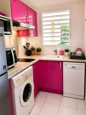 A compact kitchen with a washing machine, a dishwasher, a microwave, and a toaster. - Villa Hibalya (Saint-François)