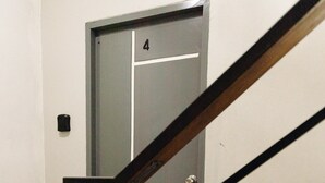 Eine Treppe mit einem Holzgeländer, das zu einer Tür mit der Nummer 4 führt.