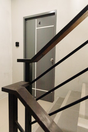A staircase with a wooden handrail leading to a door marked with the number 4. - The One Rawai Rooms (Rawai)