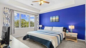 A bedroom with a bed, a television, a ceiling fan, and a window with curtains. - 931 Wedgewood - Barefoot Resort Rentals (North Myrtle Beach)