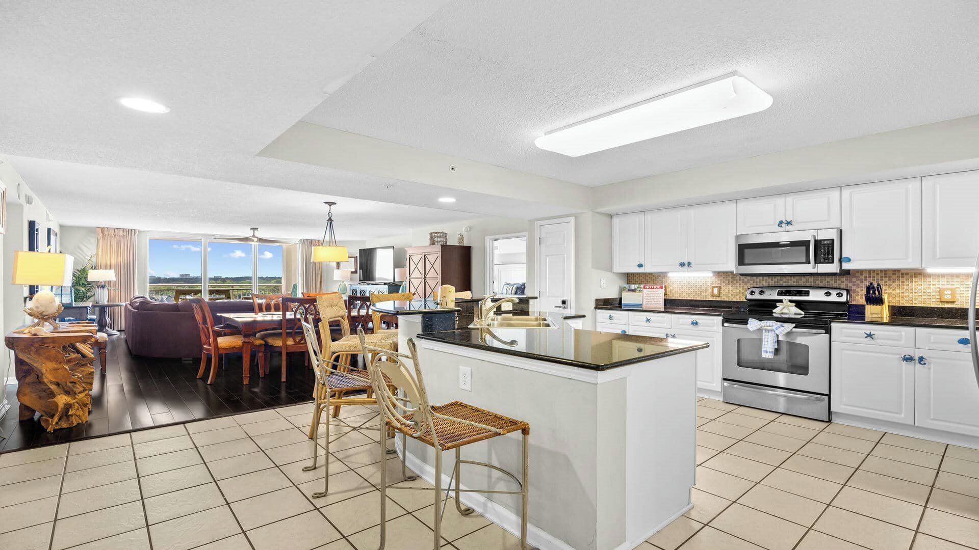 Una cocina moderna con gabinetes blancos, electrodomésticos de acero inoxidable y una isla grande.