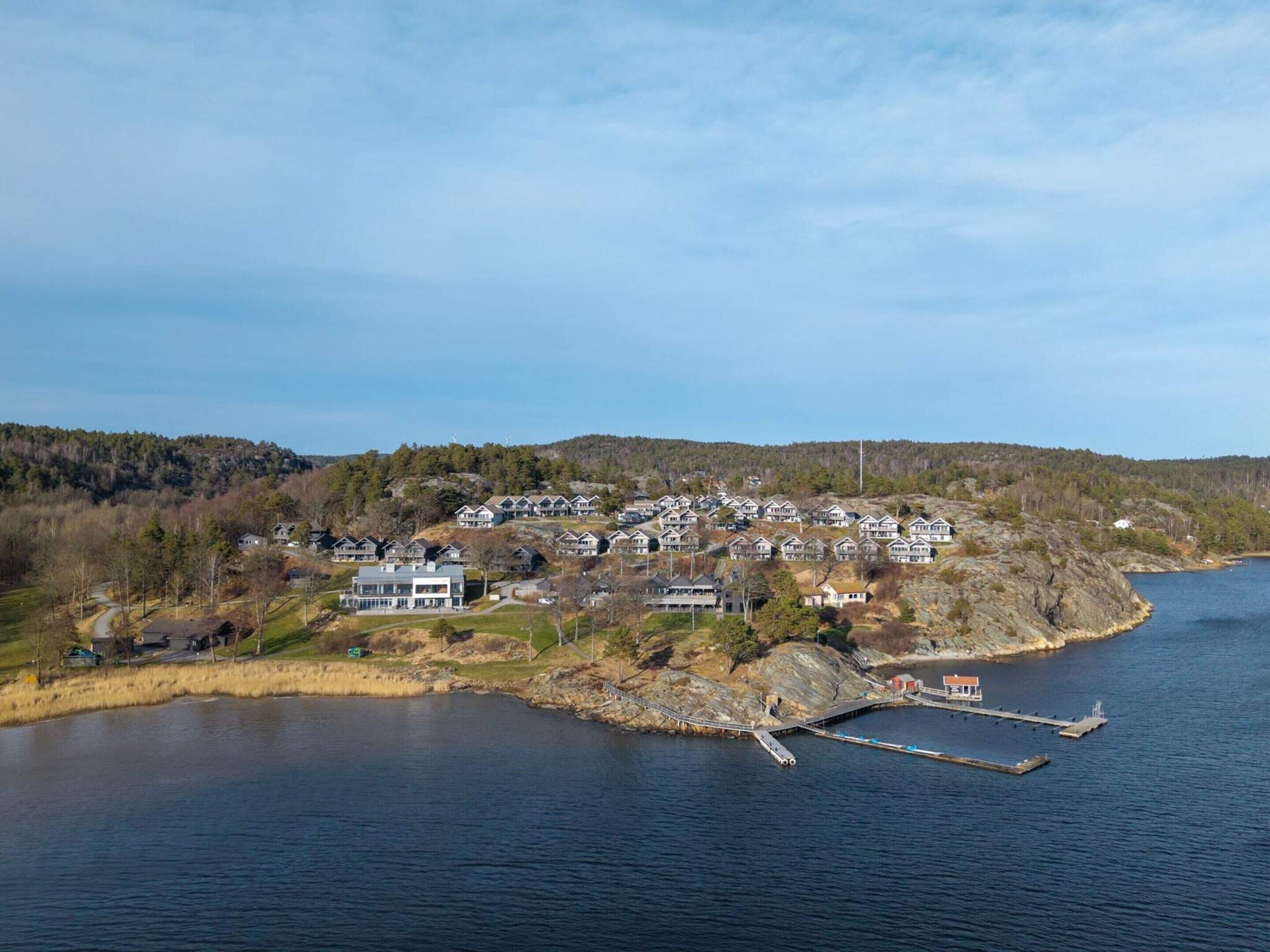 A coastal residential area with houses, a dock, and a small pier.